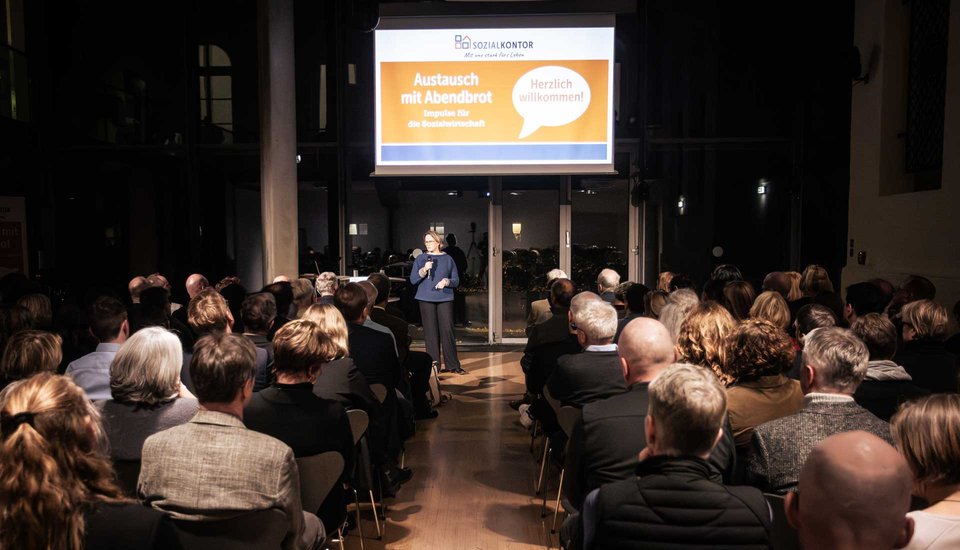 Eine sitzendes Publikum guckt auf Sozialsenatorin Melanie Schlotzhauer