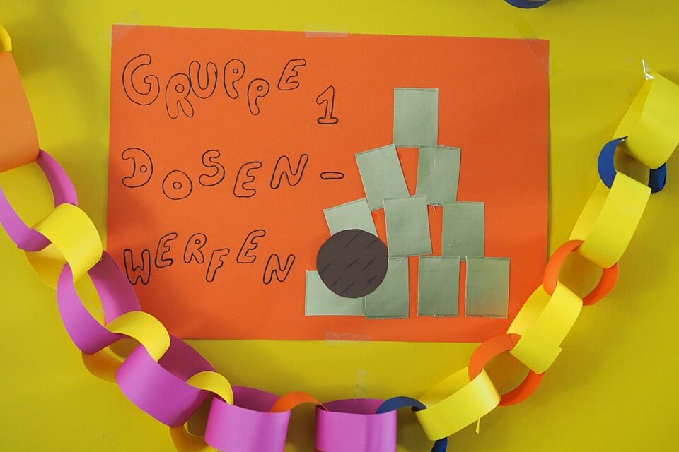 Schild auf dem Dosenwerfen steht
