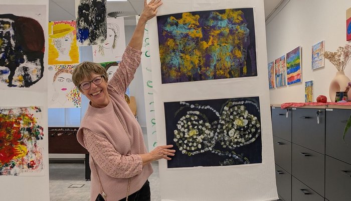 Frau zeigt lachend auf ein Bild