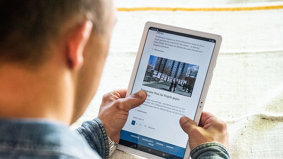 Ein Mann guckt auf ein Tablet.