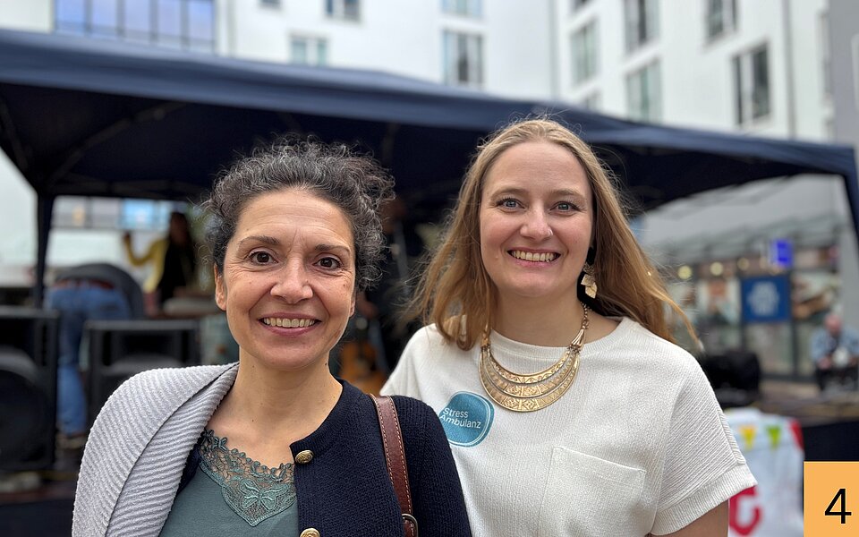 Özlem Winkler-Özkan und Inka Butz stehen beim Stadtteilfest Rothenburgsort nebeneinander und lächeln in die Kamera.
