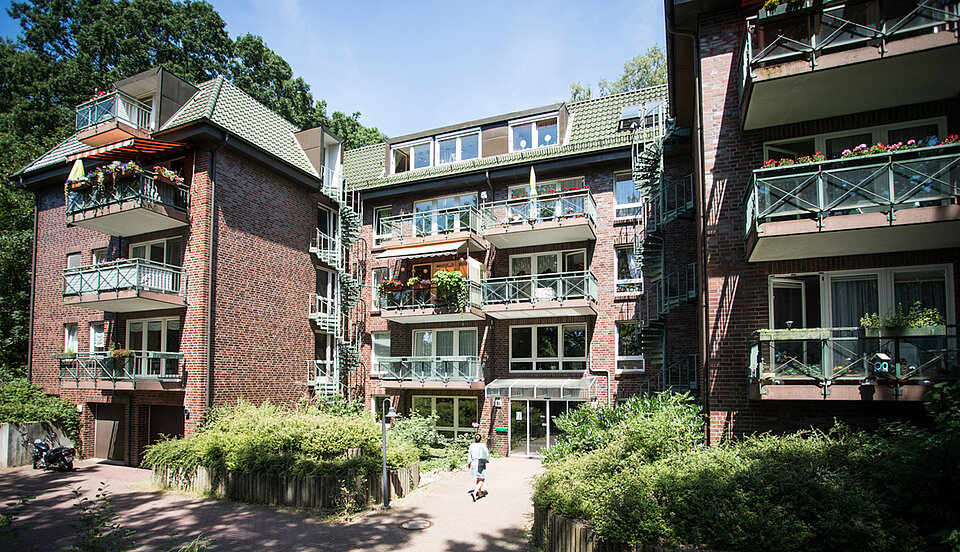 Haus im Sonnenschein und einer Person davor