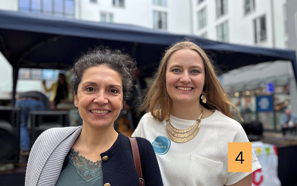 Özlem Winkler-Özkan und Inka Butz stehen beim Stadtteilfest Rothenburgsort nebeneinander und lächeln in die Kamera.