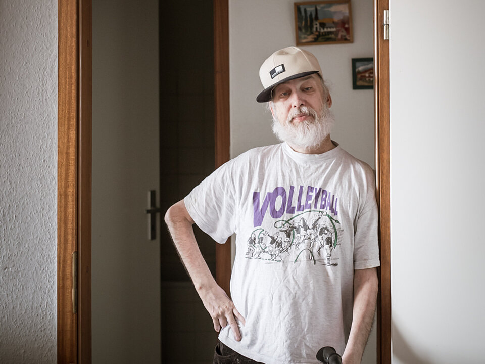 Ein älterer Mann mit Cap und einem T-Shirt mit der Aufschrift