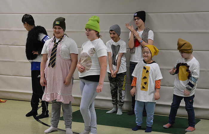 Sieben verkleidete Kinder in einer Sporthalle