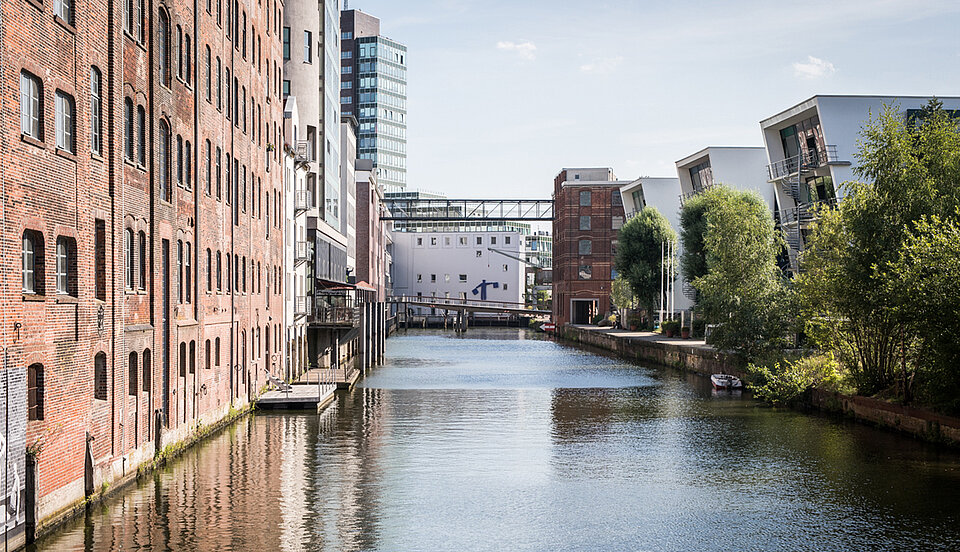 In der Nachbarschaft. Ein Kanal mit Häusern und Bäumen an den Uferseiten 
