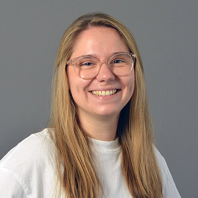 Junge Frau mit blonden langen Haaren und Brille