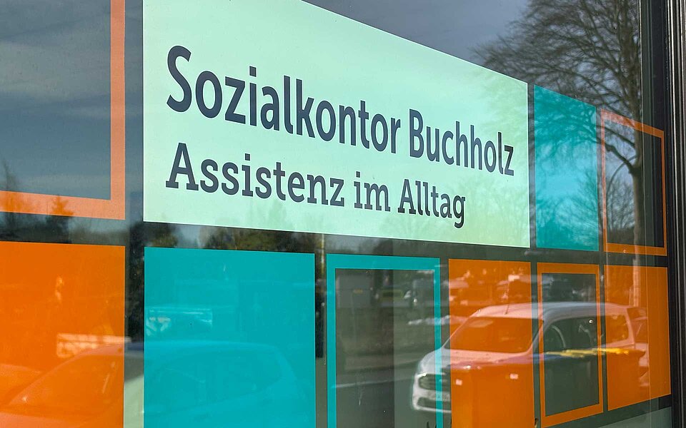 Schild mit dem Text Sozialkontor Buchholz Assistenz im Alltag