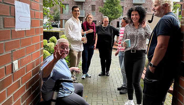 Mieter*innen, Mitarbeitende und Gäste bei der Jubiläumsfeier zu zehn Jahren Wohnen mit Assistenz Schellerdamm des Sozialkontors in Hamburg-Harburg.