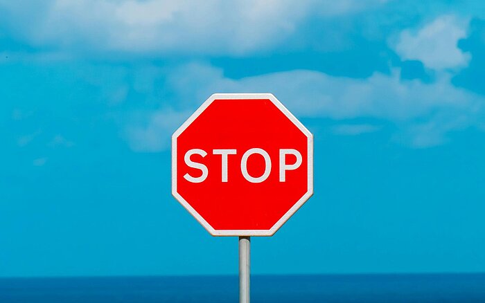 Rotes Stoppschild vor blauem Himmel