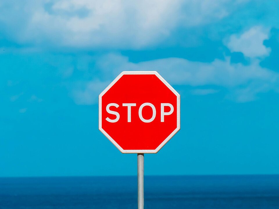 Rotes Stoppschild vor blauem Himmel