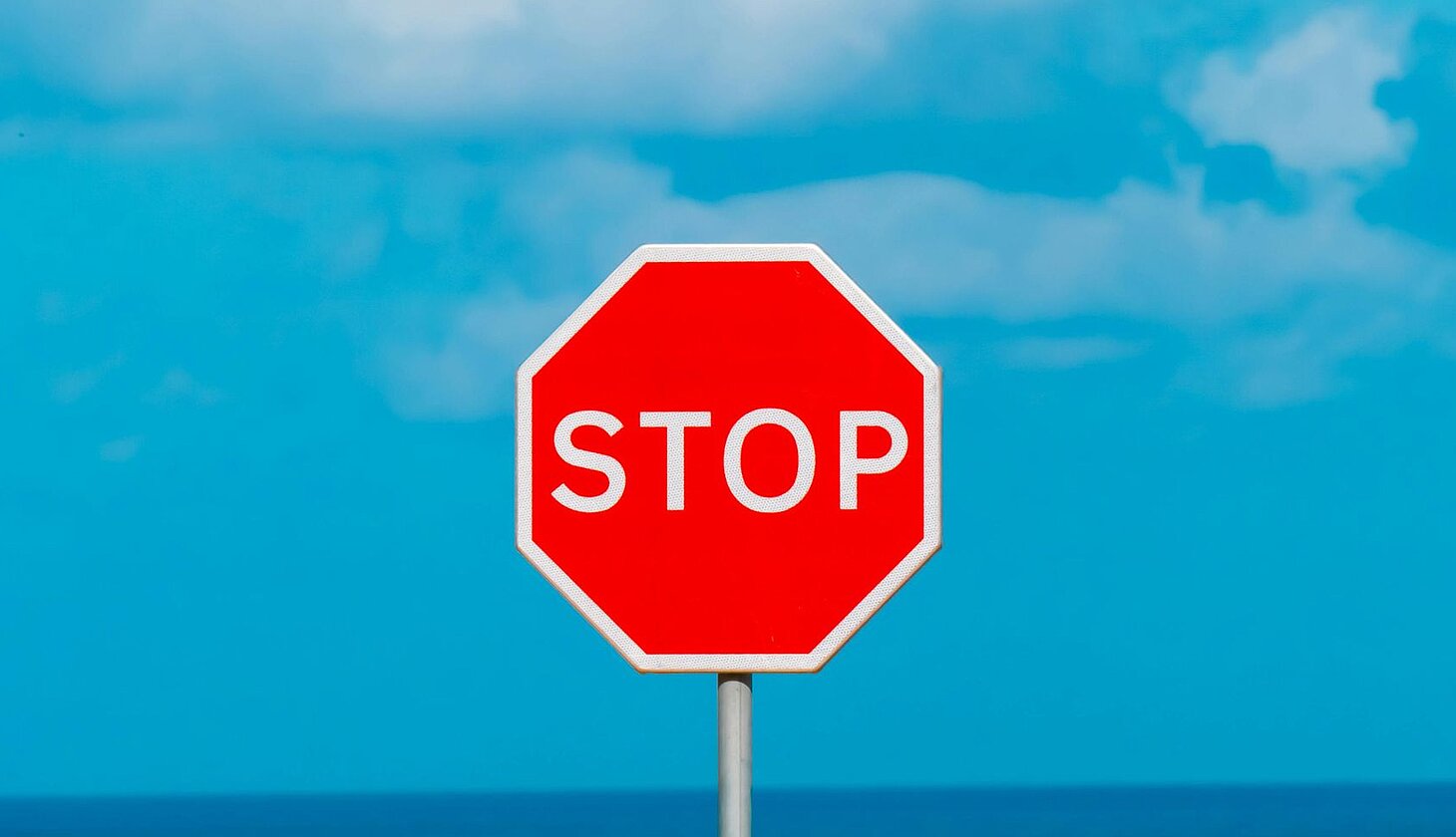 Rotes Stoppschild vor blauem Himmel