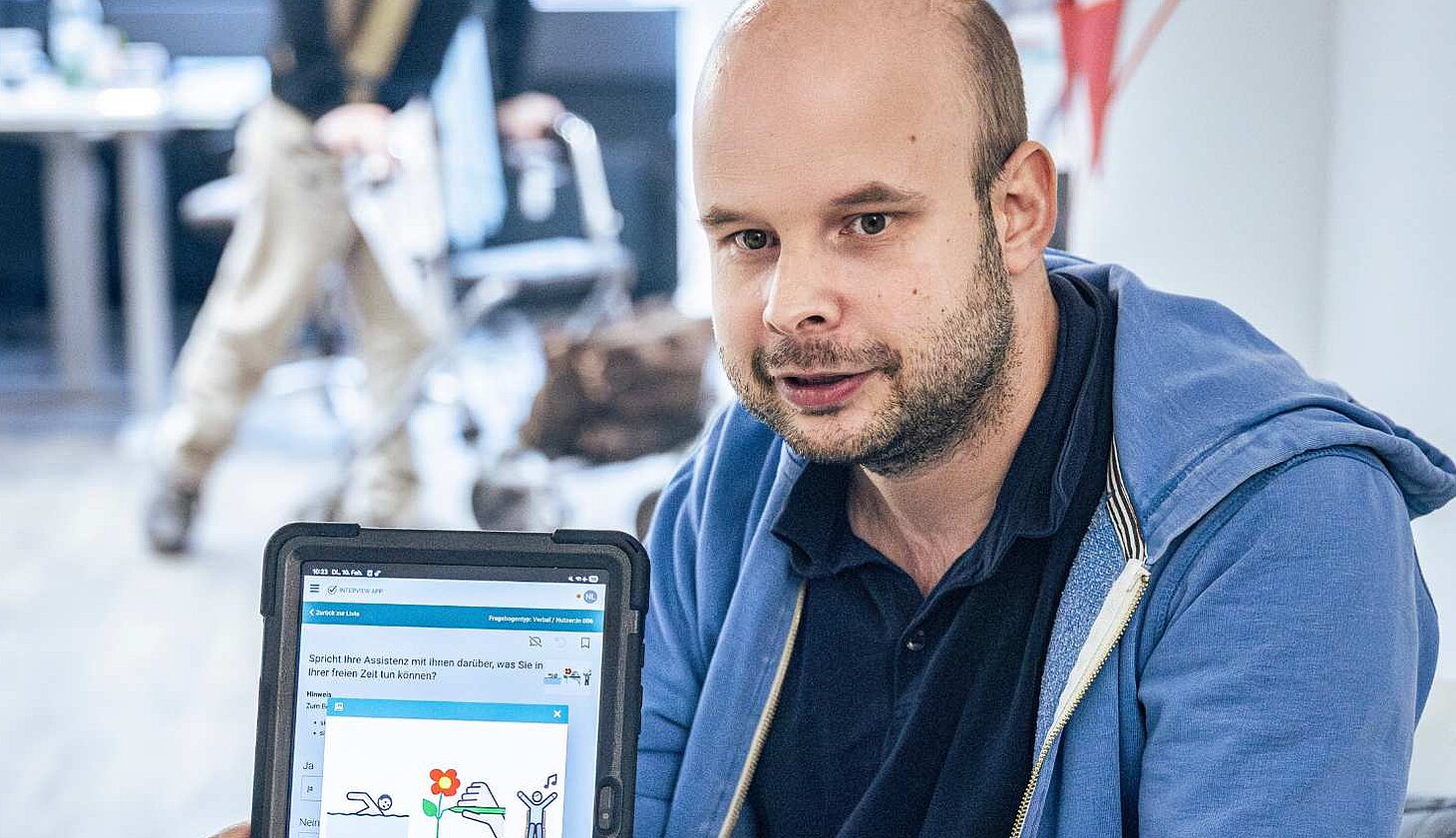 Fotograf Bernhard Gawlick zeigt auf sein Naturfoto an der Wand