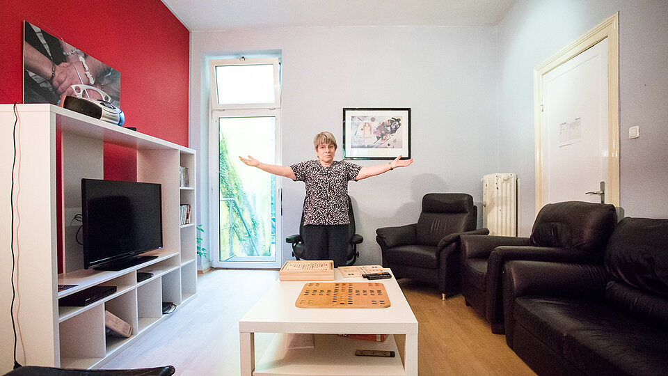 Frau steht in einem Wohnzimmer