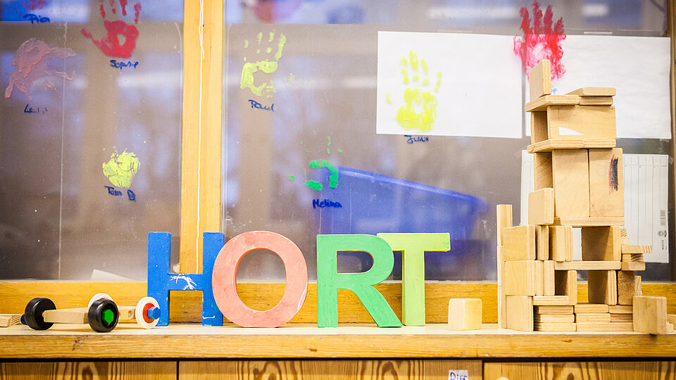 Im Hort. Eine Fensterbank, auf der bunte Holzbuchstaben stehen, die das Wort Hort bilden.