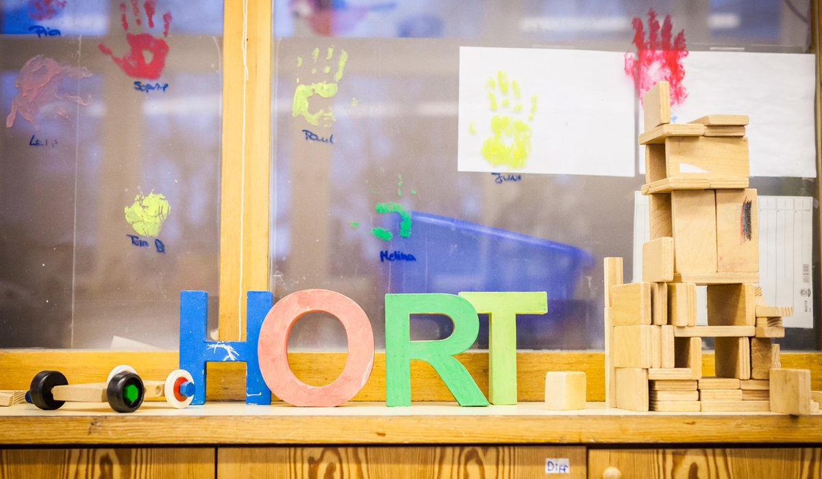 Im Hort. Eine Fensterbank, auf der bunte Holzbuchstaben stehen, die das Wort Hort bilden. 
