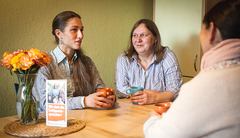 im Treffpunkt, 3 Frauen mit Kaffeebecher im Gespräch