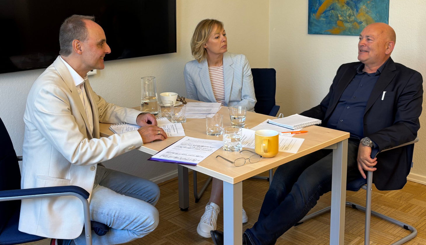 Von links: Michael Wild, Gaby Klaas, Kay Nernheim sitzen an einem Tisch in einem Büro und unterhalten sich (Foto: Sozialkontor)