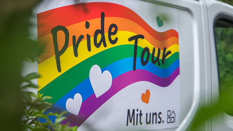 Detailaufnahme des Pride-Tour-Logos auf dem Transporter des Sozialkontors. Regenbogenfarben, Herzsymbole und der Schriftzug „Pride Tour“ stehen für Vielfalt und Akzeptanz.