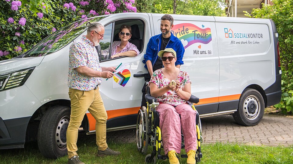 Gruppenfoto vor dem Pride-Tour-Fahrzeug des Sozialkontors: Menschen mit und ohne Behinderung sowie Mitarbeitende stehen gemeinsam für Vielfalt, Teilhabe und ein respektvolles Miteinander.