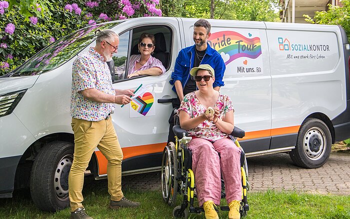 Gruppenfoto vor dem Pride-Tour-Fahrzeug des Sozialkontors: Menschen mit und ohne Behinderung sowie Mitarbeitende stehen gemeinsam für Vielfalt, Teilhabe und ein respektvolles Miteinander.
