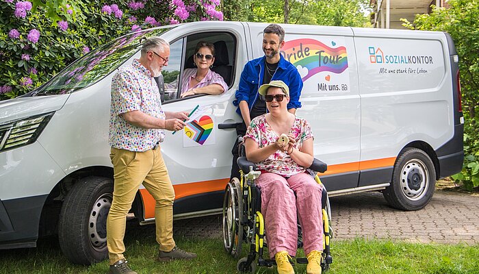 Gruppenfoto vor dem Pride-Tour-Fahrzeug des Sozialkontors: Menschen mit und ohne Behinderung sowie Mitarbeitende stehen gemeinsam für Vielfalt, Teilhabe und ein respektvolles Miteinander.