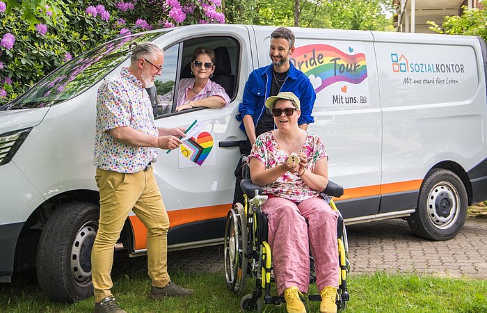 Gruppenfoto vor dem Pride-Tour-Fahrzeug des Sozialkontors: Menschen mit und ohne Behinderung sowie Mitarbeitende stehen gemeinsam für Vielfalt, Teilhabe und ein respektvolles Miteinander.